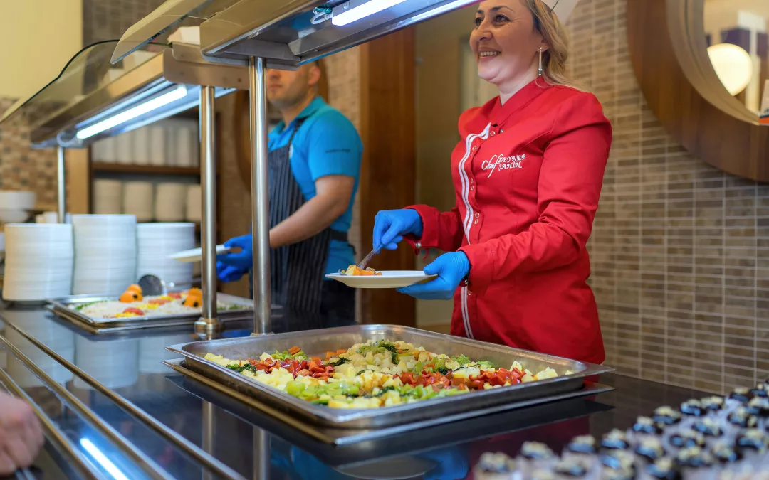 Employée en uniforme servant un repas dans un restaurant universitaire, restauration collective étudiante à Paris.